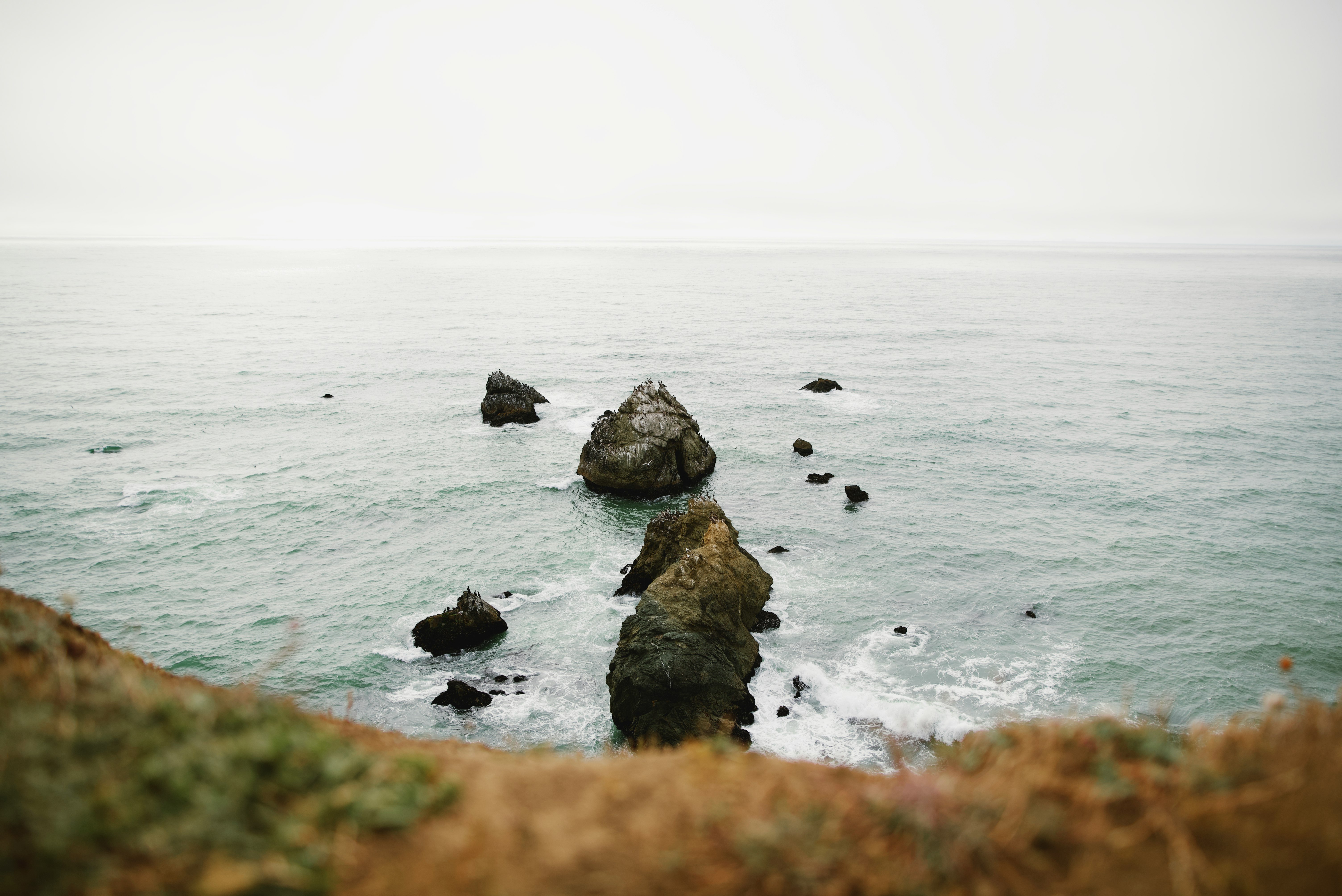 brown rock formation on sea during daytime